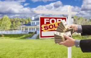 Image of man handing over cash with real estate sign
